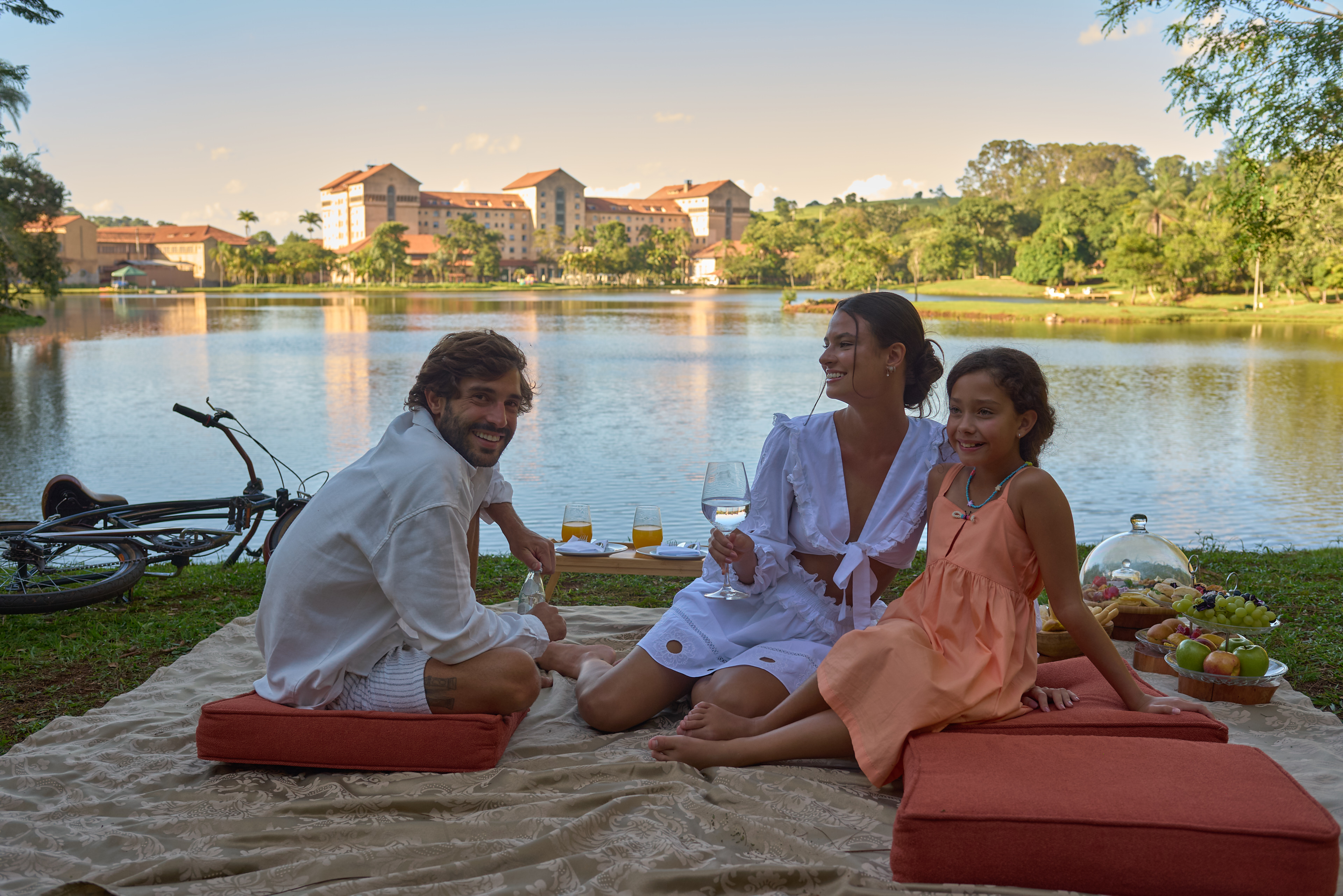 família fazendo um pique nique ar margens do lago no grande hotel